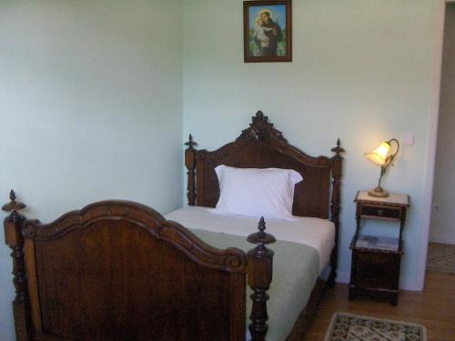 ein Schlafzimmer mit einem Bett und einer Lampe auf einem Tisch in der Unterkunft Quinta do Canto in Horta