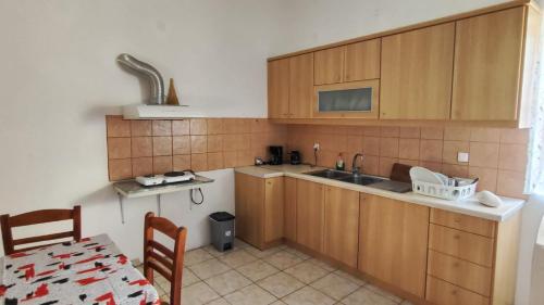 a kitchen with wooden cabinets and a table and a table and a tableablish at TRADITIONAL HOUSE ALEPIS IN AREOPOLIS in Areopoli
