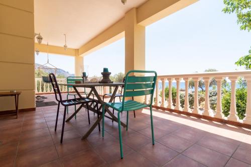 YialósにあるMarika Seaside Villaのポーチ(テーブル、椅子付)