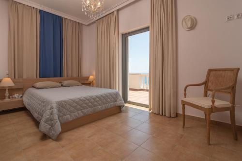 YialósにあるMarika Seaside Villaのベッドルーム1室(ベッド1台、椅子、窓付)