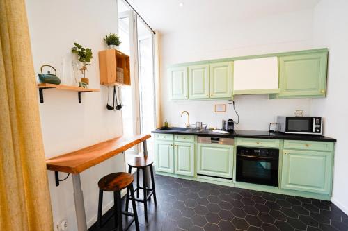 - une petite cuisine avec des placards verts et un comptoir dans l'établissement Une Pause quelque part, à Marseille
