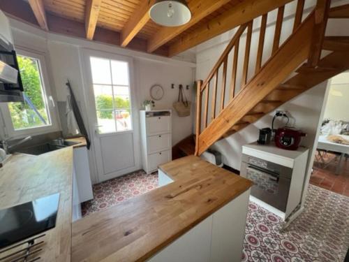 une cuisine avec un escalier en bois dans une maison dans l'établissement Maison typique - Crève-coeur, à La Bernerie-en-Retz