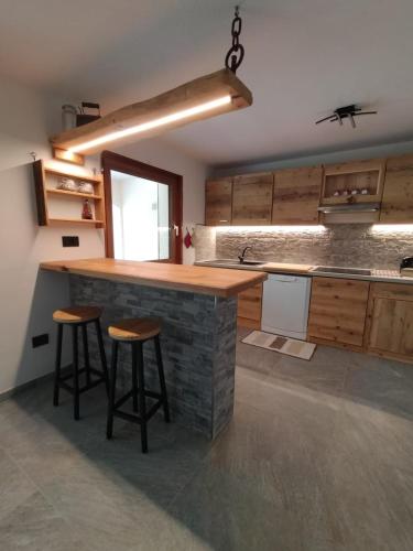 a kitchen with a stone counter and stools in it at Casa Vauterin in La Thuile