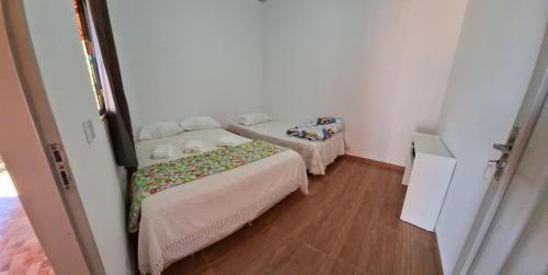 a small room with two beds and a table at Serra Dourada Mossâmedes in Mossâmedes