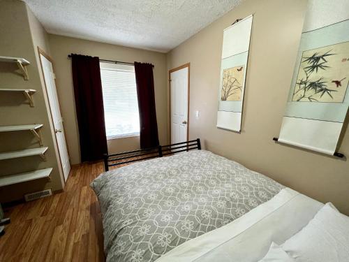 1 dormitorio con cama y ventana en Garden and Parkview Sweet Home, en Calgary