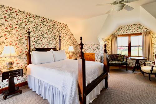 a bedroom with a large bed with floral wallpaper at Rose Farm Inn in New Shoreham