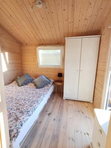 ein Schlafzimmer mit einem Bett in einer Holzhütte in der Unterkunft NA KOŃCU WSI in Ruciane-Nida