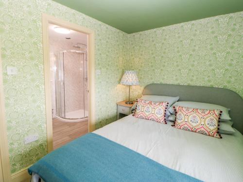 a bedroom with a bed and a walk in shower at The Granary in Morpeth