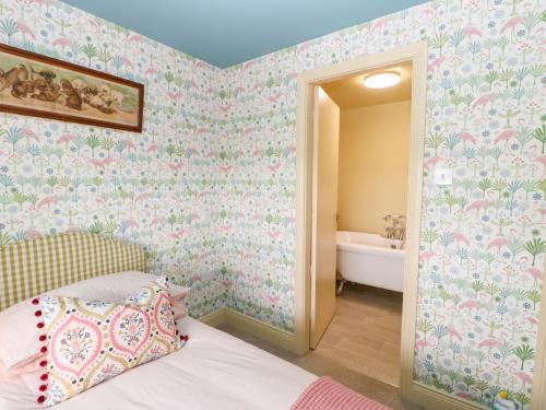 a bedroom with a bed and a bathroom with a tub at The Granary in Morpeth