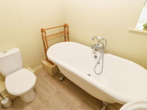 a bathroom with a white tub and a toilet at The Granary in Morpeth