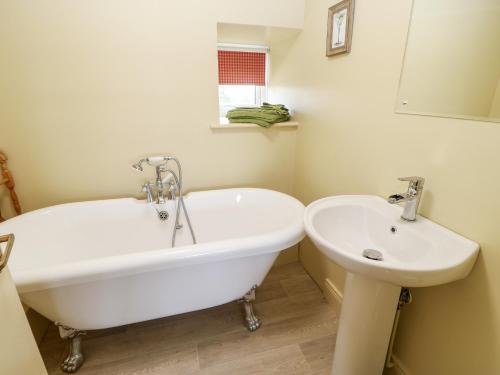 eine weiße Badewanne und ein Waschbecken im Bad in der Unterkunft The Granary in Morpeth