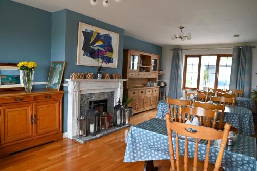 a living room with a dining table and a fireplace at The Olde Forge B & B in Caherdaniel