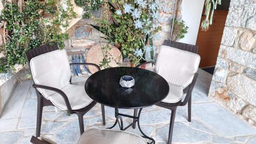 a black table and chairs with a napkin on top at TRADITIONAL HOUSE ALEPIS IN AREOPOLIS in Areopolis