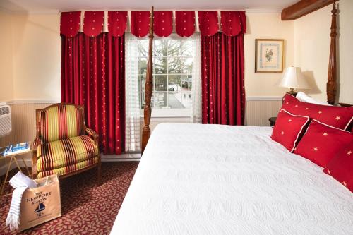 Schlafzimmer mit einem Bett und einem Fenster mit roten Vorhängen in der Unterkunft America's Cup Inn Newport in Newport