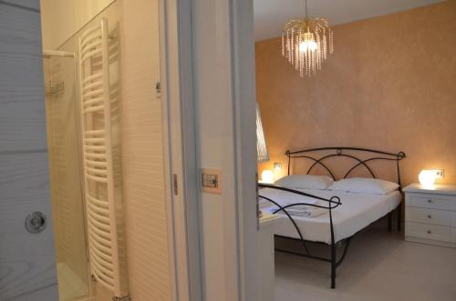 een slaapkamer met een bed en een kroonluchter bij Elena Apartment - View Lake - Private Garage in Bardolino