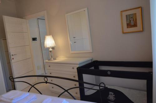 een slaapkamer met een stoel, een dressoir en een spiegel bij Elena Apartment - View Lake - Private Garage in Bardolino