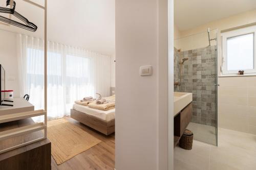 ein Bad mit einem Bett, einem Waschbecken und einem Spiegel in der Unterkunft Villa Olive Garden in Brzac