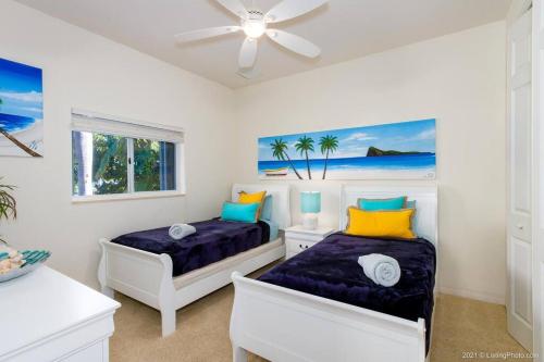 a bedroom with two beds and a ceiling fan at Villa Bremen - Pool / Spa Home in Cape Coral