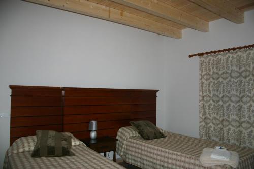 a bedroom with two beds and a wooden headboard at Amistad y convivencia 1 in Barahona