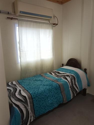 een kleine slaapkamer met een bed en een raam bij Don Omar in Posadas