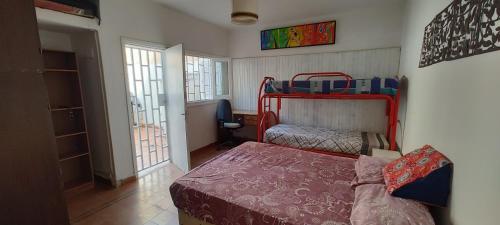 ein Schlafzimmer mit einem Bett und einem Etagenbett in der Unterkunft Habitación Privada en casa compartida para viajeros in Cordoba