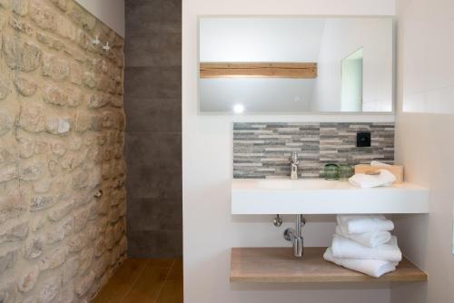 een badkamer met een wastafel en een stenen muur bij B&B Kraneveld in Haacht