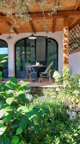a patio with two chairs and a table on a house at Giardini Penelope Resort e Spa in Ciampino