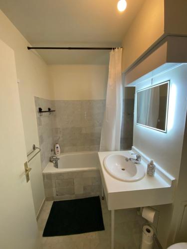 モンティニー・ル・ブルトンヌーにあるSuite full Confort Netflix Wifiのバスルーム(シンク、バスタブ、トイレ付)