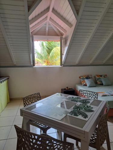une pièce avec une table, des chaises et un lit dans l'établissement STUDIO LAURIER - 4 pers - proche bourg -1-, à Terre-de-Haut