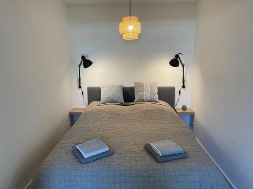 - une chambre avec un lit avec deux oreillers et deux lampes dans l'établissement NEU 2023 - Fewo mit Meerblick & Flair, à Harrislee