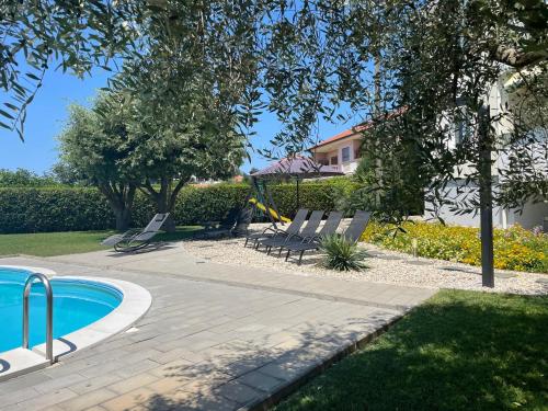 een zwembad met ligstoelen naast een huis bij Apartments Sunny Estate in Zaton