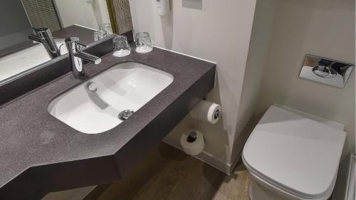 a bathroom with a sink and a toilet at Holiday Inn Derby/Nottingham by IHG in Derby
