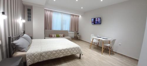 een slaapkamer met een bed, een tafel en een bank bij 2downtown.skg in Thessaloniki