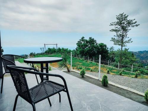 a table and chairs sitting on a patio with a view at Flora-A in Chakvi