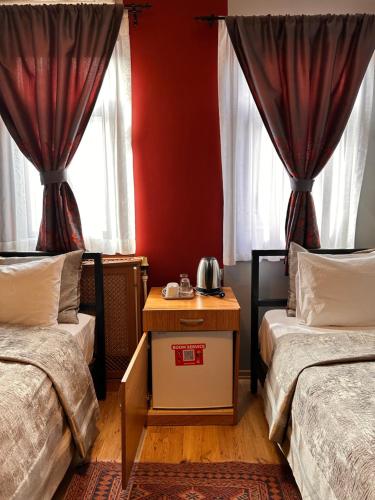 Duas camas num quarto com paredes vermelhas e janelas em Ahmet Efendi Evi em Istambul