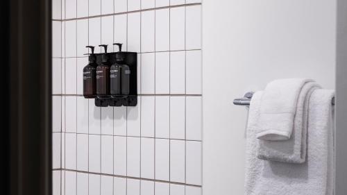 a bathroom with two black bottles on a white tiled wall at Trailborn Rocky Mountains Outpost in Estes Park