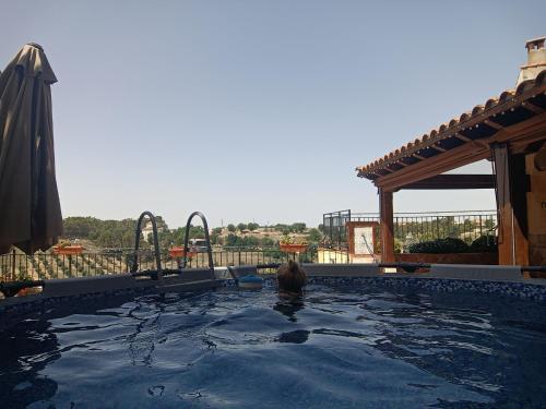 a woman is sitting in a swimming pool at Casa de la Abuela Pili in Colmenar de Oreja