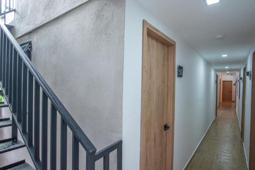 a hallway with stairs and a wooden door at Vita Hotel Boutique - Aire Acondicionado & Desayuno in Medellín