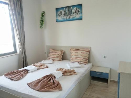 um quarto com 2 camas e toalhas em Хоризонт М em Sveti Vlas
