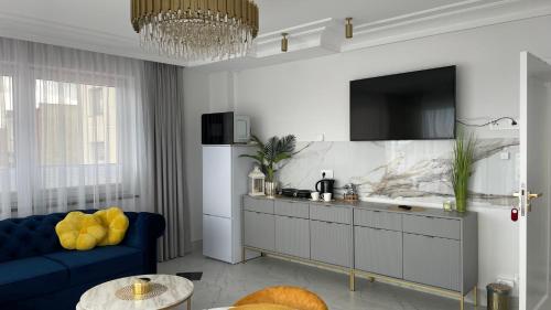 a living room with a blue couch and a tv at Ośrodek Wczasowy REWA in Rewa