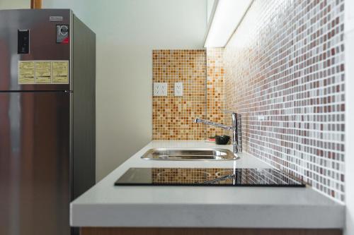 a kitchen with a sink and a refrigerator at Jacana Amazon Wellness Resort in Paramaribo