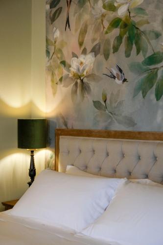 a bedroom with a bed with a painting on the wall at Tenuta Bussia - Wine Relais & Spa in Monforte dʼAlba