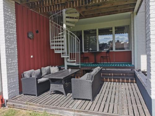 um deque com uma mesa e cadeiras numa casa em Saxvikens vandrarhem em Mora