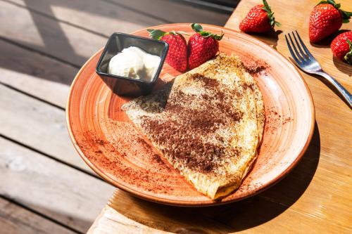 a plate of toast with butter and strawberries on a table at Vecchio Mulino StarsBox in Entracque