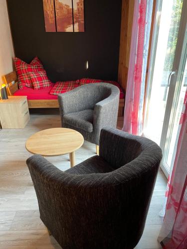a living room with two chairs and a table and a couch at Haus Silverfern in Förolach