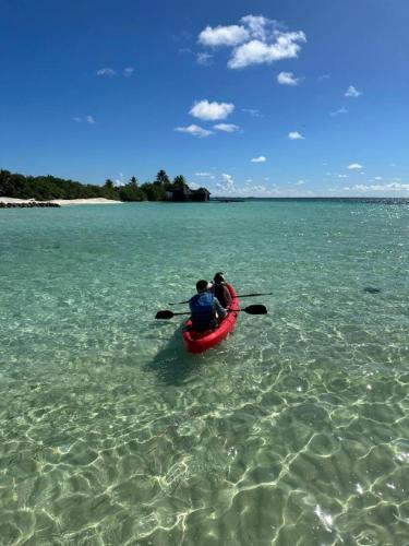 a couple of people in a kayak in the water at The Bilimbi Guesthouse & Inn in Huraa