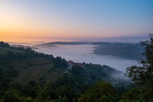 a view of a foggy valley with a house on a hill at Casa Andreini in Mombarcaro
