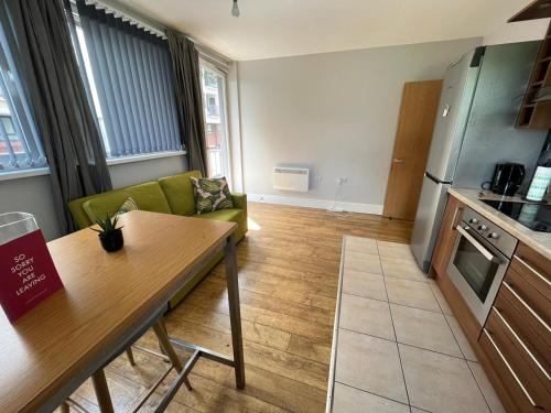 a kitchen and living room with a couch and a table at London Modern Flat near transports in London