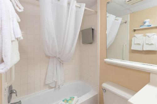 een badkamer met een bad, een toilet en een spiegel bij Studio w Balcony and Ocean View - Boardwalk One - 203 in Ocean City