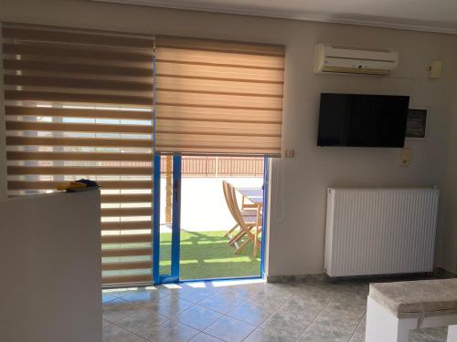 ein Wohnzimmer mit einer Glasschiebetür und einem TV in der Unterkunft Penthouse360view in Karystos